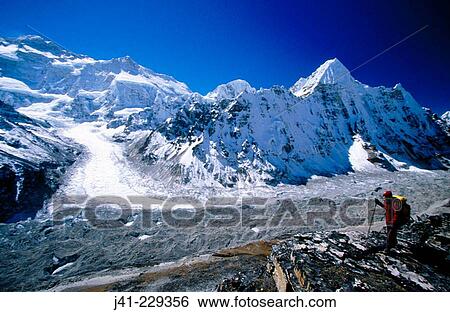 Stock Photograph - Trekker under Kanchenjunga. North face and Wedge Peak from Pangpema. East Nepal. Fotosearch