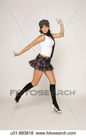 Trendy model jumping in a studio setting View Large Photo Image Stock Photo - Trendy model jumping in a studio setting. Fotosearch