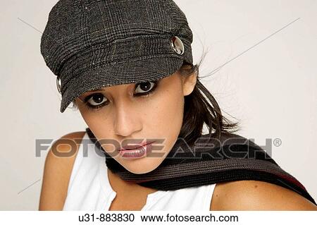 Stock Image - Trendy model posing looking at the camera in a studio setting. Fotosearch