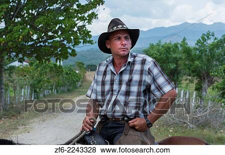 Trinidad Cuba cowboy on horse in country riding portrait in ranch with hat and chaps and cowboy clothes. View Large Photo Image Stock Photo - Trinidad Cuba cowboy on horse in country riding portrait in ranch with hat and chaps and cowboy clothes.. Fotosearch