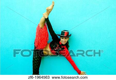 Stock Image - Trinidad Cuba dancer in costume and hat against blue wall and smile.. Fotosearch