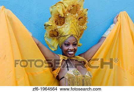Trinidad Cuba dancer in show costume gold against blue wall and colorful head dress and smile. View Large Photo Image Picture - Trinidad Cuba dancer in show costume gold against blue wall and colorful head dress and smile.. Fotosearch