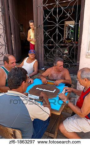 Trinidad Cuba street scene of men playing dominoes in front of home on street View Large Photo Image Stock Photo - Trinidad Cuba street scene of men playing dominoes in front of home on street. Fotosearch
