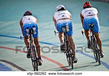 Stock Image - Trio of triathletes training on the bike in a velodrome in Alcobendas Madrid / Trio de triatletas entrenando en la bicicleta en un velodromo de Alcobendas Madrid. Fotosearch