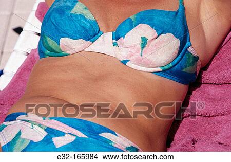 Tummy of middle aged woman wearing a bikini View Large Photo Image Picture - Tummy of middle aged woman wearing a bikini. Fotosearch