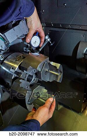Stock Photo - Tuning mooring. Checking with dial indicator. Automated CNC lathe. Machined Indecober. Machining of precision parts in series. Automotive industry. Berriz. Bizkaia. Basque Country. Spain.. Fotosearch