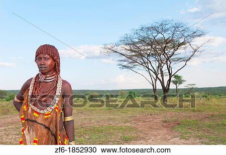 Stock Image - Turmi Ethiopia Africa village Lower Omo Valley Hamar Hammer tribe portrait of woman in village at sunset with First Wife necklace 24. Fotosearch