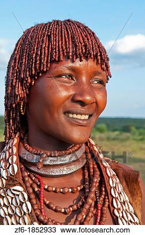 Stock Image - Turmi Ethiopia Africa village Lower Omo Valley Hamar Hammer tribe portrait of woman in village at sunset with First Wife necklace 24. Fotosearch