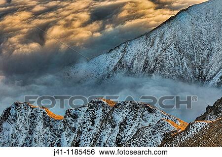 Tussock covered ridge at dawn, partly covered by winter snow, above sea of cloud over Lake Wanaka, Central Otago, Southern Alps, New Zealand. View Large Photo Image Stock Photograph - Tussock covered ridge at dawn, partly covered by winter snow, above sea of cloud over Lake Wanaka, Central Otago, Southern Alps, New Zealand.. Fotosearch