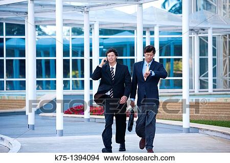 Picture - Twin businessmen in a hurry. Fotosearch