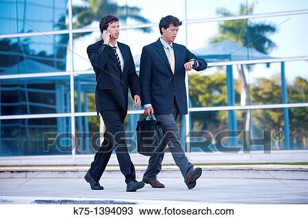 Stock Image - Twin businessmen in a hurry. Fotosearch