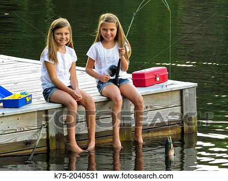 Twin sisters catching fish View Large Photo Image Stock Image - Twin sisters catching fish. Fotosearch