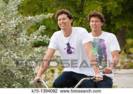 Twins riding tandem bike View Large Photo Image Stock Image - Twins riding tandem bike. Fotosearch