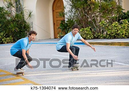 Picture - Twins skateboarding. Fotosearch