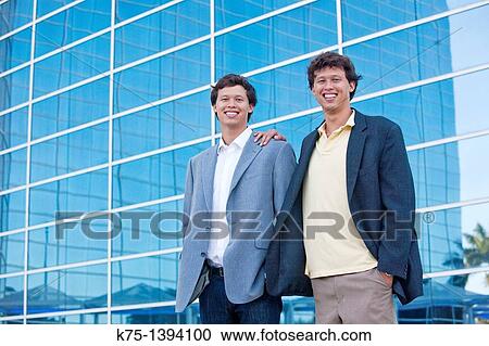 Twins standing outside of office building View Large Photo Image Stock Image - Twins standing outside of office building. Fotosearch