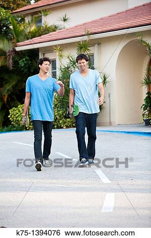 Twins walking with skateboards View Large Photo Image Stock Photograph - Twins walking with skateboards. Fotosearch