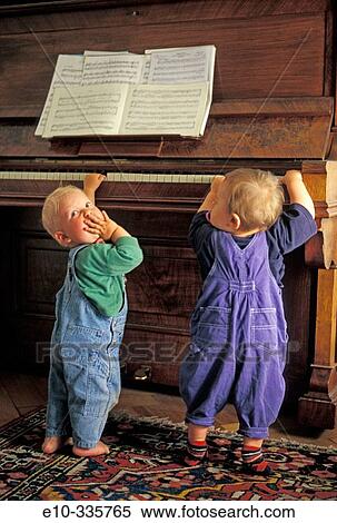 Stock Photography - Two 11 month old boys playing the piano. Fotosearch