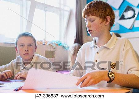 Two 12 year old boys, sitting in class, concentrating View Large Photo Image Stock Photo - Two 12 year old boys, sitting in class, concentrating. Fotosearch