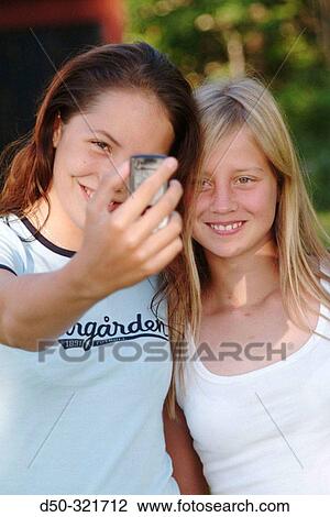 Two 13 year old girls having fun taking their picture on a digital camera enabled mobile phone (cell phone). Stockholm, Sweden View Large Photo Image Stock Image - Two 13 year old girls having fun taking their picture on a digital camera enabled mobile phone (cell phone). Stockholm, Sweden. Fotosearch