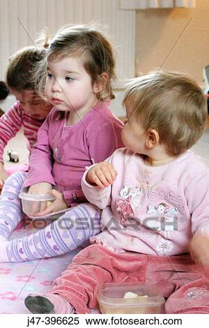 Two 3 year old girls and a 1 year old girl, sitting on the floor eating fruit View Large Photo Image Stock Photography - Two 3 year old girls and a 1 year old girl, sitting on the floor eating fruit. Fotosearch