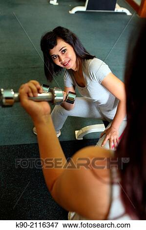 Stock Photo - Two asian women doing weightlifting with dumbbells, Jakarta, Indonesia, Southeast Asia.. Fotosearch