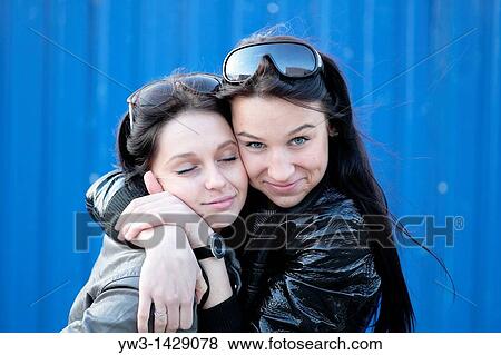 two beautiful brunette outdoor portrait against blue wall View Large Photo Image Stock Photo - two beautiful brunette outdoor portrait against blue wall. Fotosearch