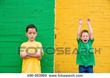Stock Photo - Two boys against colorful yellow and green wall. Fotosearch