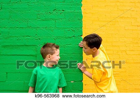 Two boys against yellow and green wall View Large Photo Image Stock Photo - Two boys against yellow and green wall. Fotosearch