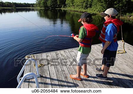 Two boys aged 7 and 9 fishing for smallmouth bass from a wharf on Ponhook lake, Nova Scotia, Canada. View Large Photo Image Picture - Two boys aged 7 and 9 fishing for smallmouth bass from a wharf on Ponhook lake, Nova Scotia, Canada.. Fotosearch