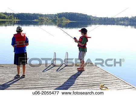 Two boys aged 7 and 9 fishing for smallmouth bass from a wharf on Ponhook lake, Nova Scotia, Canada. View Large Photo Image Stock Photo - Two boys aged 7 and 9 fishing for smallmouth bass from a wharf on Ponhook lake, Nova Scotia, Canada.. Fotosearch