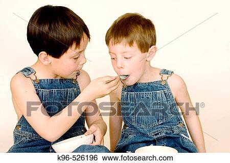 Stock Photograph - two boys eating. Fotosearch