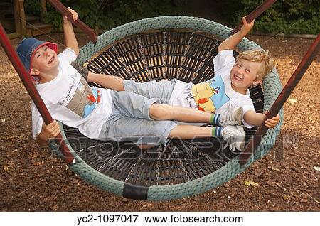 Two boys on a swing showing movement at Gressenhall museum of rural life in North Norfolk Uk View Large Photo Image Stock Photo - Two boys on a swing showing movement at Gressenhall museum of rural life in North Norfolk Uk. Fotosearch
