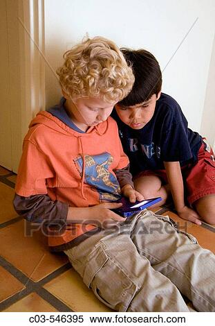Two boys, one Russian-born and adopted, the other Chinese-American, play a computer game together in Laguna Niguel, CA. View Large Photo Image Stock Photography - Two boys, one Russian-born and adopted, the other Chinese-American, play a computer game together in Laguna Niguel, CA.. Fotosearch