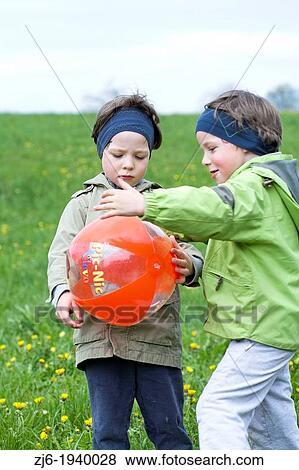 Two boys - twins playing outdoor on a meadow with a ball. Slovenian countryside. View Large Photo Image Stock Photo - Two boys - twins playing outdoor on a meadow with a ball. Slovenian countryside.. Fotosearch