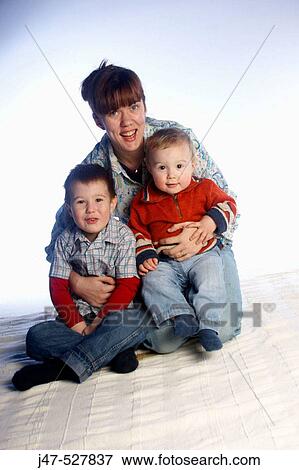two brothers, aged 3 and 2, sitting together on the floor, studio, with their Mother holding them View Large Photo Image Stock Photo - two brothers, aged 3 and 2, sitting together on the floor, studio, with their Mother holding them. Fotosearch