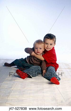 two brothers, aged 3 and 2, sitting together on the floor, studio View Large Photo Image Stock Photo - two brothers, aged 3 and 2, sitting together on the floor, studio. Fotosearch