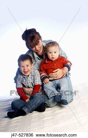 two brothers, aged 3 and 2, sitting together on the floor, studio, with their Mother holding them View Large Photo Image Stock Photograph - two brothers, aged 3 and 2, sitting together on the floor, studio, with their Mother holding them. Fotosearch