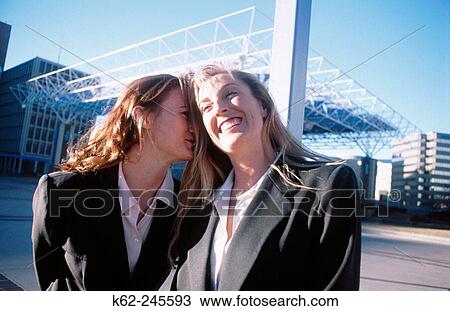Stock Image - Two businesswomen laughing in downtown square. Alburquerque. Nuevo Mexico. USA. Fotosearch