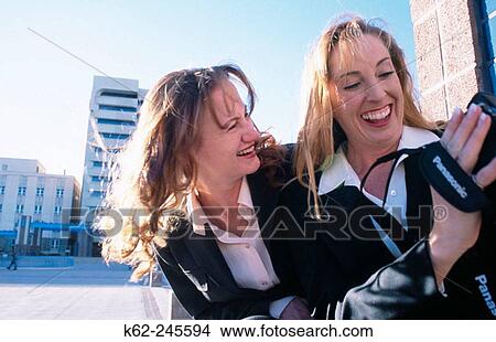 Picture - Two businesswomen with a video camara in downtown square. Alburquerque. Nuevo Mexico. USA. Fotosearch