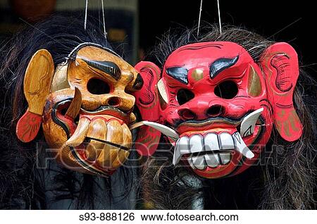 Two carved wooden masks used in Balinese dances hanging on strings in Ubud, Bali. View Large Photo Image Stock Photograph - Two carved wooden masks used in Balinese dances hanging on strings in Ubud, Bali.. Fotosearch