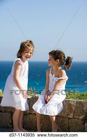 Two caucasian girls in front of a blue sea View Large Photo Image Stock Photography - Two caucasian girls in front of a blue sea. Fotosearch