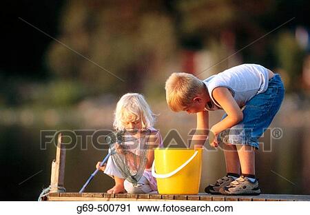 Two children, 3 and 6 years old, catch small fish with a landing net, from a jetty. Batvik. V? sterbotten. Sweden. View Large Photo Image Stock Image - Two children, 3 and 6 years old, catch small fish with a landing net, from a jetty. Batvik. V? sterbotten. Sweden.. Fotosearch
