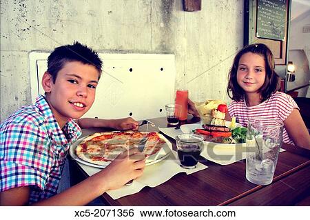 Two children eating in a slow food restaurant, Rome, Italy View Large Photo Image Stock Photograph - Two children eating in a slow food restaurant, Rome, Italy. Fotosearch