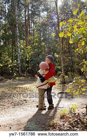 Two children embrace each other in autumn forest View Large Photo Image Stock Photograph - Two children embrace each other in autumn forest. Fotosearch