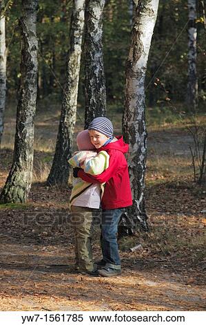 Stock Photography - Two children embrace each other in autumn forest. Fotosearch