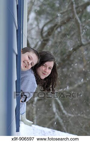 Two children look out the windows on a cold snowy day Maybe a snowman later View Large Photo Image Stock Photo - Two children look out the windows on a cold snowy day Maybe a snowman later. Fotosearch