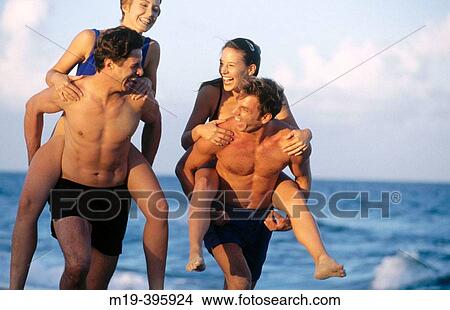 two couples at the beach on piggyback View Large Photo Image Picture - two couples at the beach on piggyback. Fotosearch