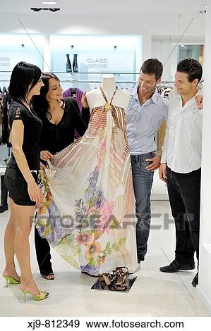 Stock Photo - Two couples choosing a dress in the shop.. Fotosearch