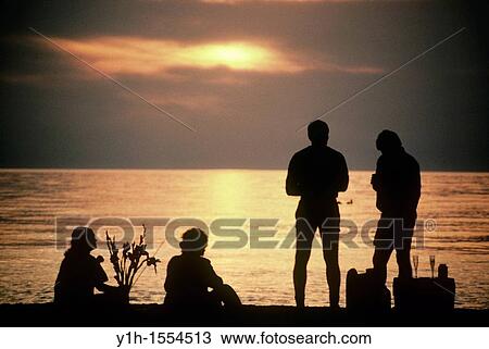 Two couples picnic on the beach watching the sun set and sharing food View Large Photo Image Stock Image - Two couples picnic on the beach watching the sun set and sharing food. Fotosearch