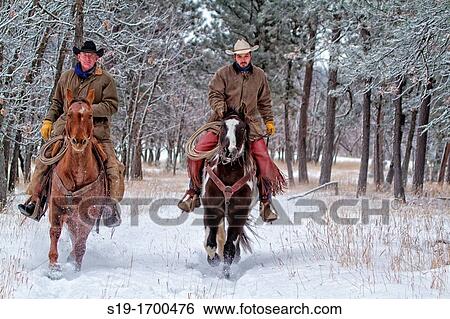 Two cowboys riding horses in the snow View Large Photo Image Stock Photograph - Two cowboys riding horses in the snow. Fotosearch